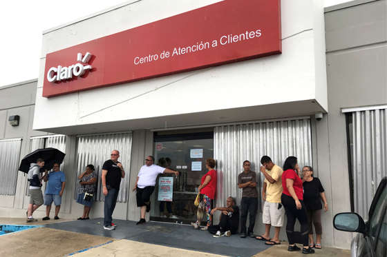 Slide 3 of 162: Local residents wait outside a Claro mobile phone company shop, trying to buy phones, days after Hurricane Maria in Puerto Rico, September 30, 2017. Picture taken on September 30, 2017.