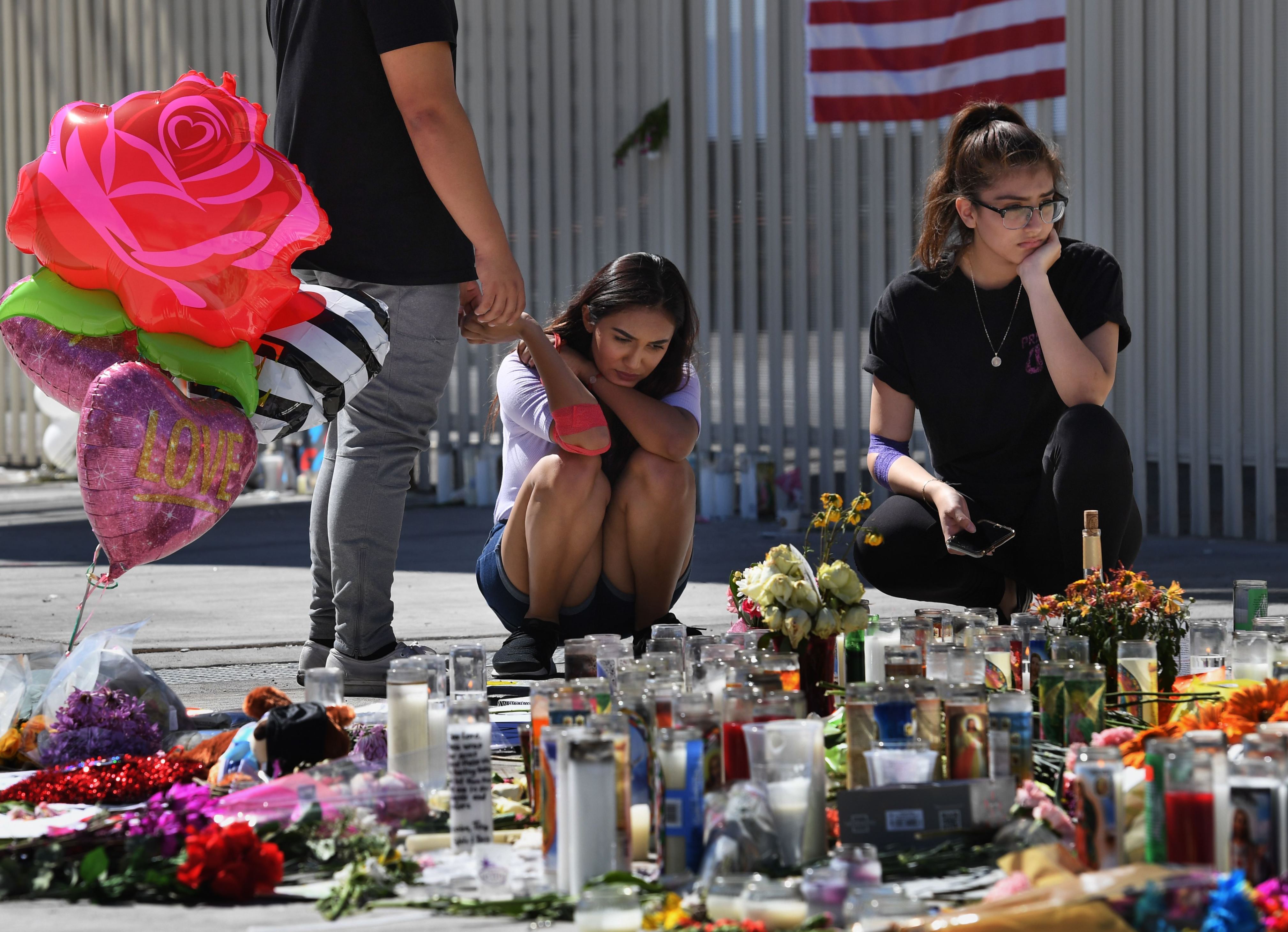 Diapositiva 5 de 57: Briana Calderon (C) and Cinthya Olbera pray at a makeshift memorial on the Las Vegas Strip in Las Vegas, Nevada on October 3, 2017, after a gunman killed 59 people and wounded more than 500 others when he opened fire from the Mandalay Hotel on a country music festival. Police said the gunman, a 64-year-old local resident named as Stephen Paddock, had been killed after a SWAT team responded to reports of multiple gunfire from the 32nd floor of the Mandalay Bay, a hotel-casino next to the concert venue.