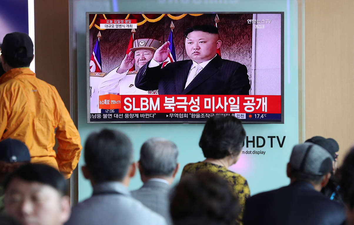 People watch a live television program showing North Korean leader Kim Jong Un salutes during a parade in Pyongyang, North Korea, at the Seoul train station in Seoul, South Korea, Saturday, April 15, 2017.