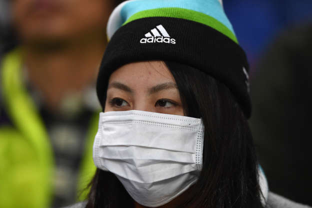 21 枚のスライドの 3 枚目: A fan wears a protective mask during the FIFA Club World Cup second round match between Jeonbuk Hyundai and Club America at Suita City Football Stadium on December 11, 2016 in Suita, Japan.