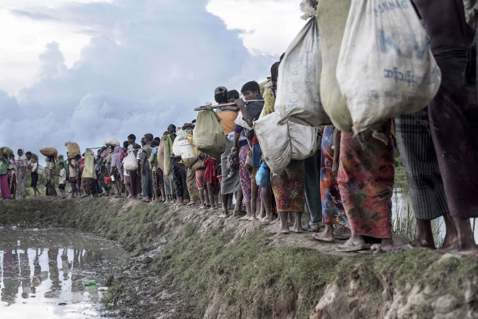 Διαφάνεια 4 από 36: Rohingya refugees walk after crossing the Naf river from Myanmar into Bangladesh in Whaikhyang on October 9, 2017.