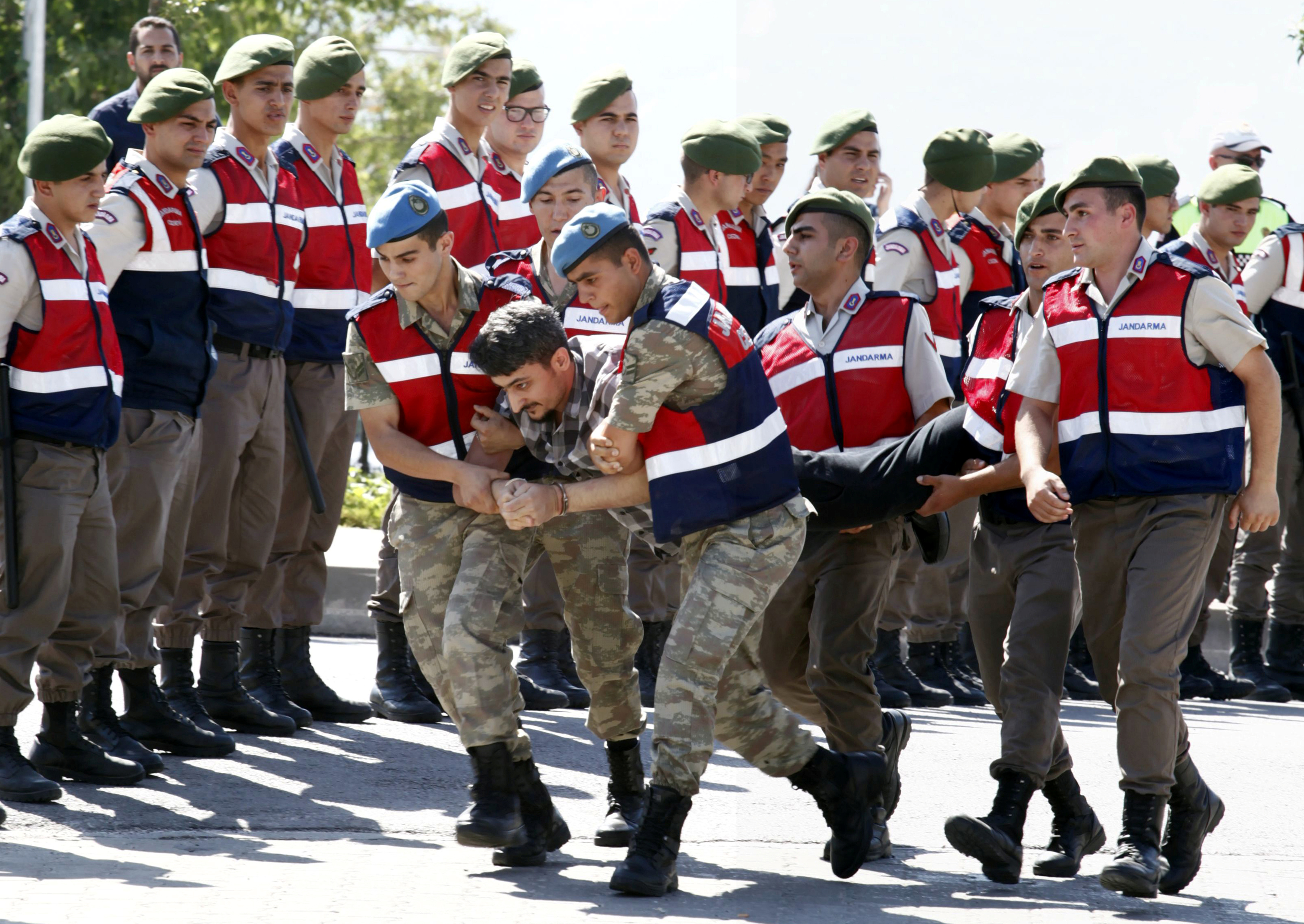 Διαφάνεια 7 από 36: A soldier accused of attempting to assassinate Turkish President Tayyip Erdogan on the night of the failed July 15, 2016 coup is carried by gendarmes to the courthouse in Mugla, Turkey July 14, 2017