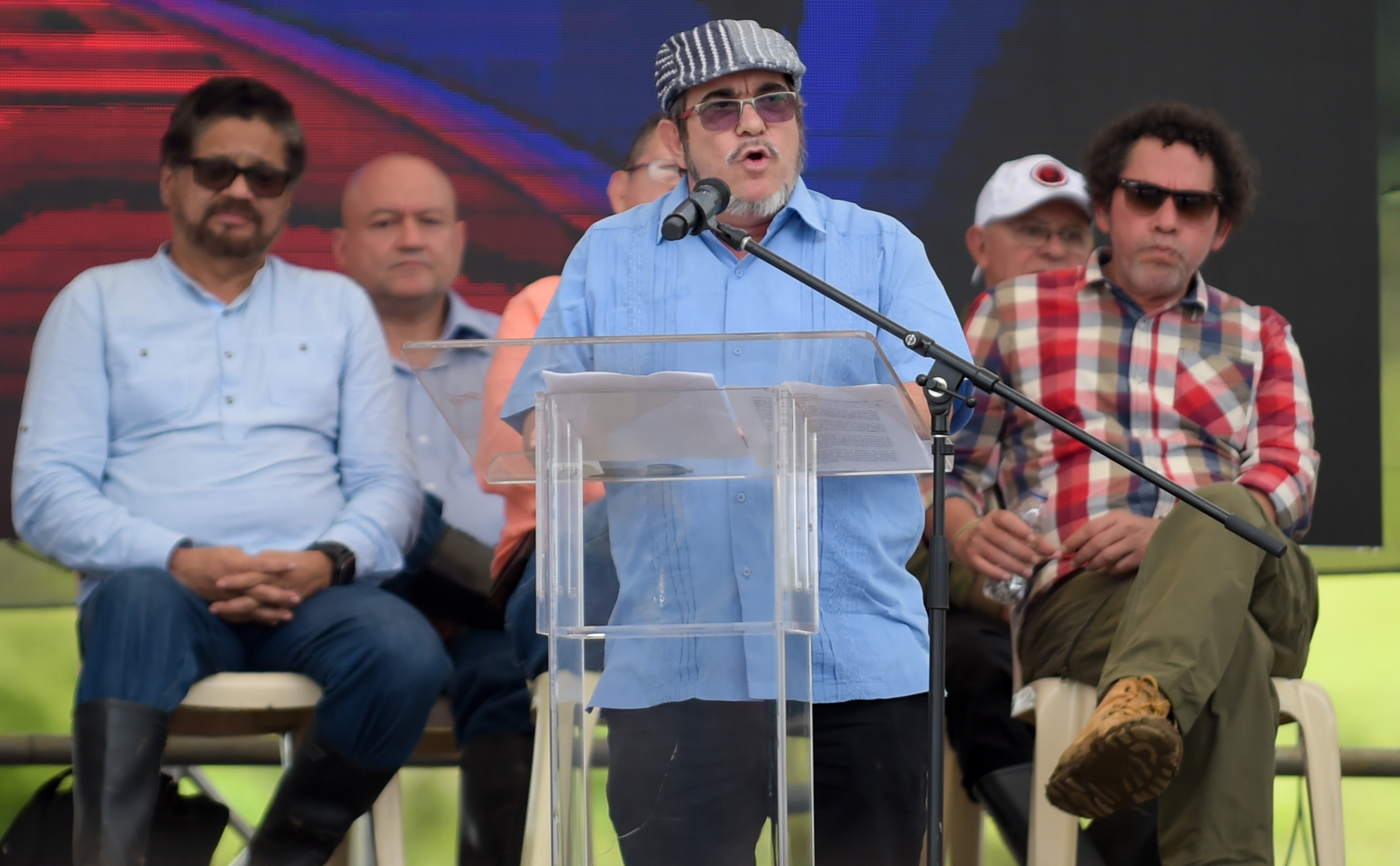 Διαφάνεια 24 από 36: FARC rebel leader Rodrigo Londono Echeverri, known as 'Timochenko' (C), delivers a speech during the final act of abandonment of arms and the FARC's end as an armed group at Transitional Standardization Zone Mariana Paez, Buena Vista, Mesetas municipality, Colombia on June 27, 2017. / A