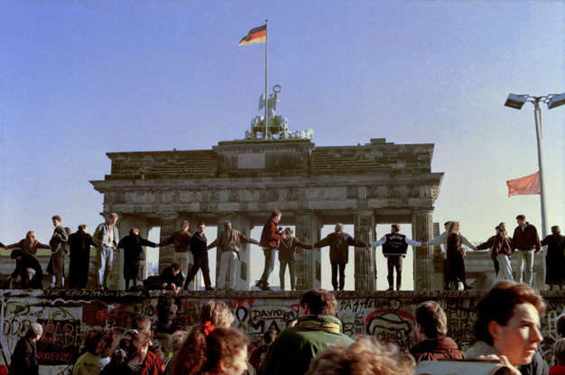 Slide 9 of 10: This Nov. 10, 1989 file photo shows Berliners singing and dancing on top of the Berlin wall to celebrate the opening of East-West German borders. Thousands of East German citizens moved into the West after East German authorities opened all border crossing points to the West. In the background is the Brandenburg Gate. Monday, Nov. 9, 2009 marks the 20th anniversary of the fall of the Berlin Wall.