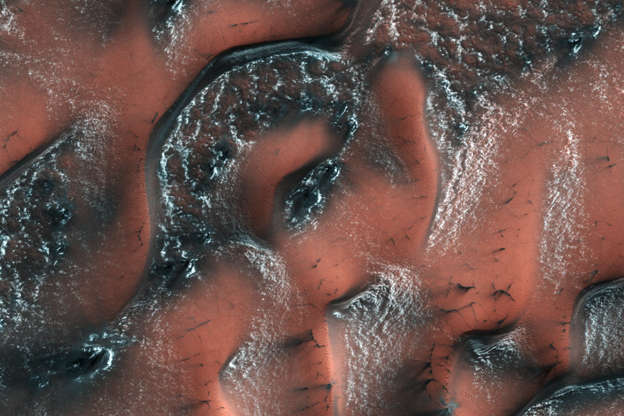 Slide 19 of 86: An image taken by the High Resolution Imaging Science Experiment (HiRISE) camera on NASA's Mars Reconnaissance Orbiter shows spring in the Northern hemisphere on May 21, 2017. Snow and ice made of carbon dioxide, or dry ice, covers the dunes. When the sun shines in the spring, the ice cracks and escaping gas carries dark sand out from the dune below. NASA/JPL/University of Arizona/Handout via REUTERS ATTENTION EDITORS - THIS IMAGE WAS PROVIDED BY A THIRD PARTY