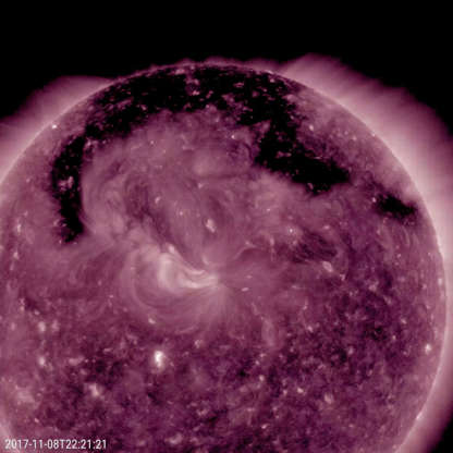 Sun's coronal holes - Solar Dynamics Observatory/GSFC/NASA Slide 8 of 86: A broad hole in the corona was the Sun's dominant feature November 7-9, 2017, as shown in this image from NASA's Solar Dynamics Observatory. The hole is easily recognizable as the dark expanse across the top of the Sun and extending down in each side. Coronal holes are magnetically open areas on the Sun that allow high-speed solar wind to gush out into space. They always appear darker in extreme ultraviolet. This one was likely the source of bright aurora that shimmered for numerous observers, with some reaching down even to Nebraska.