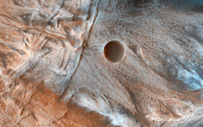 Slide 23 of 86: A view of the surface of Mars released by NASA on March 7, 2017, shows viscous, lobate flow features commonly found at the bases of slopes in the mid-latitudes of Mars, and are often associated with gullies. These are bound by ridges that resemble terrestrial moraines, suggesting that these deposits are ice-rich, or may have been ice-rich in the past. NASA/JPL-Caltech/Univ. of Arizona/Handout via REUTERS ATTENTION EDITORS - THIS IMAGE WAS PROVIDED BY A THIRD PARTY