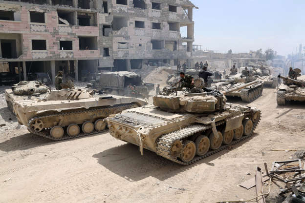 Slide 2 of 51: TOPSHOT - A picture taken on April 8, 2018, shows Syrian Army soldiers gathering in an area on the eastern outskirts of Douma, as they continue their fierce offensive to retake the last opposition holdout in Eastern Ghouta. The Syrian government unleashed a ferocious assault on the then-rebel stronghold of Eastern Ghouta on February 18, aiming to crush Islamist and jihadist groups on the doorstep of the capital. / AFP PHOTO / STRINGER (Photo credit should read STRINGER/AFP/Getty Images)