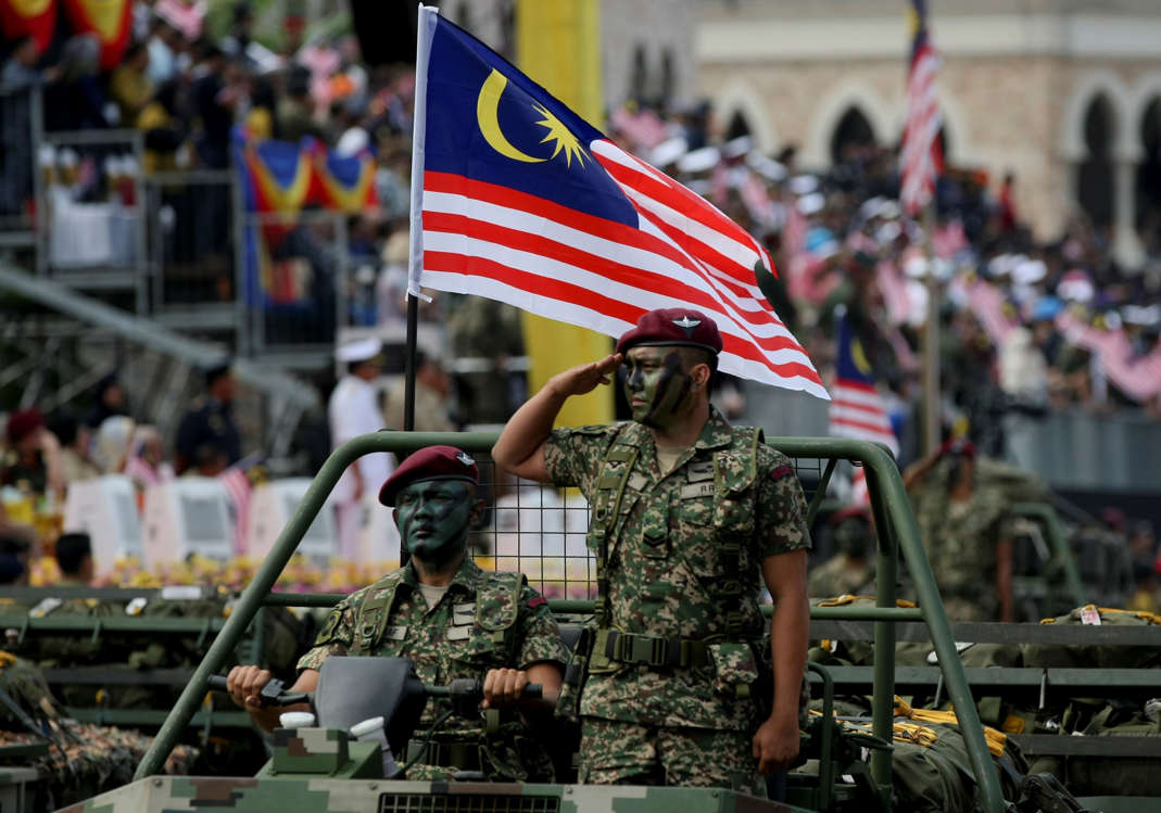 Slide 10 of 51: Malaysian military personnel salute during the 60th National Day celebrations at the Independence Square in Kuala Lumpur, Malaysia, on Thursday, Aug. 31, 2017. Aug. 31 marks the day that the Federation of Malaya gained its independence from the British in 1957. (AP Photo/Daniel Chan)