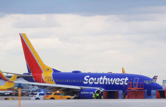 Slide 3 of 6: Emergency personnel monitor the damaged engine of Southwest Airlines Flight 1380, which diverted to the Philadelphia International Airport this morning after the airline crew reported damage to one of the aircraft's engines, on a runway in Philadelphia, Pennsylvania U.S. April 17, 2018.