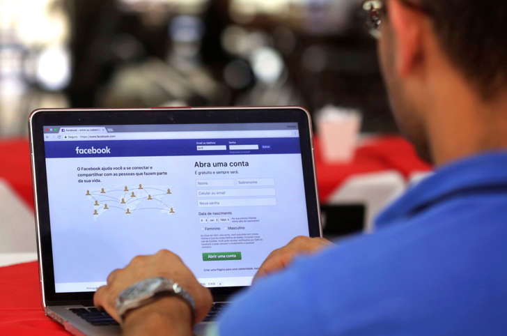 FILE - In this Thursday, Jan. 4, 2018, file photo, a man enters his Facebook page, at a restaurant in Brasilia, Brazil. Federal prosecutors in Latin America's biggest country have opened an investigation to determine if Cambridge Analytica illegally used the profiles of millions of Brazilian Facebook users. (AP Photo/Eraldo Peres, File)