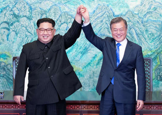 Slide 27 de 30: South Korean President Moon Jae-in and North Korean leader Kim Jong Un raise their hands at the truce village of Panmunjom inside the demilitarized zone separating the two Koreas, South Korea, April 27, 2018.   Korea Summit Press Pool/Pool via Reuters