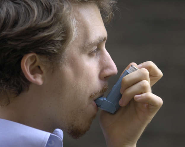 Male using an inhaler.