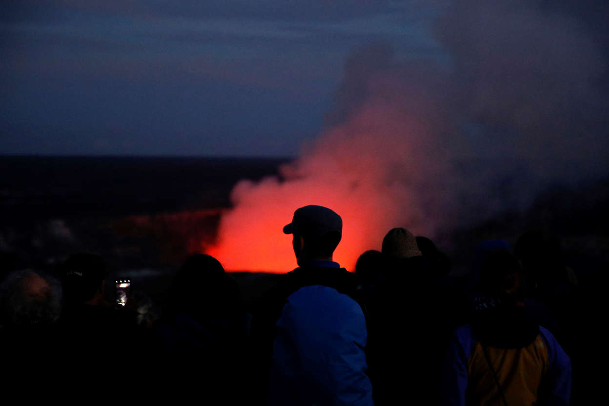 Slide 3 of 105: Visitors take pictures as Kilauea's summit crater glows red in Volcanoes National Park, Hawaii, Wednesday, May 9, 2018. Geologists warned Wednesday that Hawaii's Kilauea volcano could erupt explosively and send boulders, rocks and ash into the air around its summit in the coming weeks. (AP Photo/Jae C. Hong)