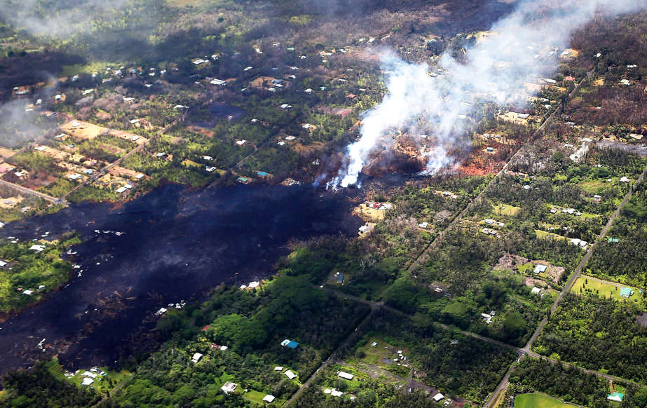 Slide 2 of 119: PAHOA, HI - MAY 11:  Smoke and volcnic gases rise as lava cools in the Leilani Estates neighborhood, in the aftermath of eruptions and lava flows from the Kilauea volcano on Hawaii's Big Island, on May 11, 2018 in Pahoa, Hawaii. The U.S. Geological Survey said a recent lowering of the lava lake at the volcano's Halemaumau crater "has raised the potential for explosive eruptions" at the volcano. Vog, a haze or smog containing gases, smoke and dust from volcanic eruptions, may eventually spread from the eruptions to other islands in Hawaii.  (Photo by Mario Tama/Getty Images)