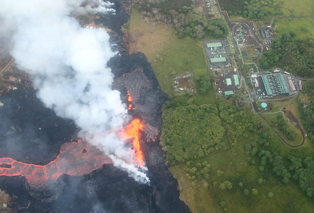 Slide 2 of 176: Lava erupts and flows from a Kilauea volcano fissure, near to the Puna Geothermal Venture (PGV) plant (TOP R), on Hawaii's Big Island on May 21, 2018 near Pahoa, Hawaii. Officials are concerned that 'laze', a dangerous product produced when hot lava hits cool ocean water, will affect residents. Laze, a word combination of lava and haze, contains hydrochloric acid steam along with volcanic glass particles.