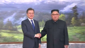 a man wearing a suit and tie: Korean leaders hold surprise meeting
