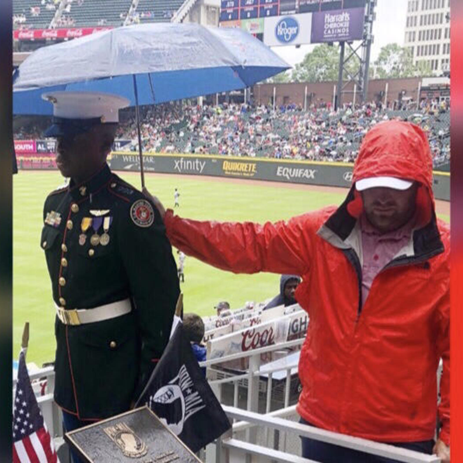 "Respect" Braves fan holds umbrella for Marine Corps JROTC member
