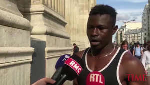 a man standing in front of a building: Interview with Migrant Hero Who Rescued Child Dangling from Balcony