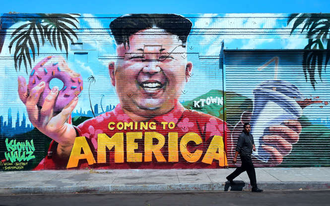 Slide 3 of 138: A pedestrian walks past a mural titled 'Coming To America' depicting North Korean leader Kim Jong-un holding a donut and milkshake by graffiti artsists @welinoo, @balstroem and @sorenarildsen in Los Angeles, California on May 14, 2018, created as part of the Ktown Wallz Project in the city's Koreatown neighborhod. - US President Donald Trump is scheduled to meet with North Korean leader Kim Jong Un on June 12, 2018 in Singapore. (Photo by Frederic J. BROWN / AFP) / RESTRICTED TO EDITORIAL USE - MANDATORY MENTION OF THE ARTIST UPON PUBLICATION - TO ILLUSTRATE THE EVENT AS SPECIFIED IN THE CAPTION        (Photo credit should read FREDERIC J. BROWN/AFP/Getty Images)