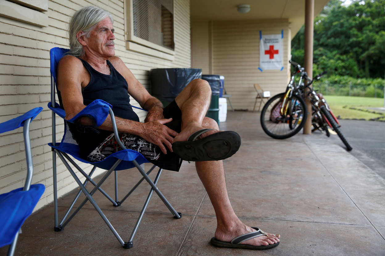 Slide 4 of 100: Michael McGuire, 70, who was forced by volcanic activity to leave his home in Leilani Estates, sits outside an evacuation center in Keaau during ongoing eruptions of the Kilauea Volcano in Hawaii, U.S., June 10, 2018.