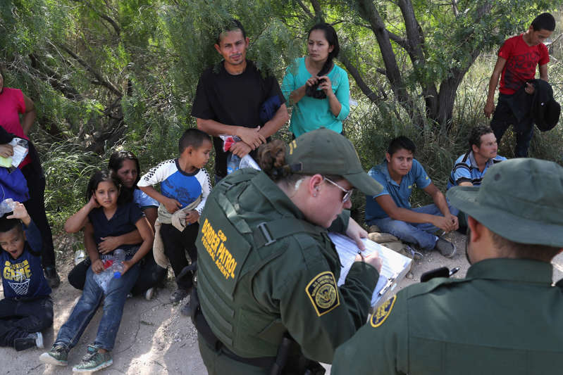 中美洲寻求庇护者等待，因为美国边境巡逻人员于2018年6月12日在德克萨斯州麦卡伦附近将他们的团体拘留。 这些家庭随后被送往美国海关与边境保护局（CBP）加工中心进行分离。 美国边境当局正在执行特朗普政府对无证移民的零容忍政策。 美国司法部长杰夫塞申斯还表示，移民原籍国的家庭暴力和帮派暴力将不再使他们有资格获得政治庇护身份。