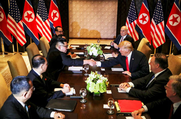Slide 1 of 51: U.S. President Donald Trump shakes hands with North Korea's leader Kim Jong Un before their expanded bilateral meeting at the Capella Hotel on Sentosa island in Singapore June 12, 2018.