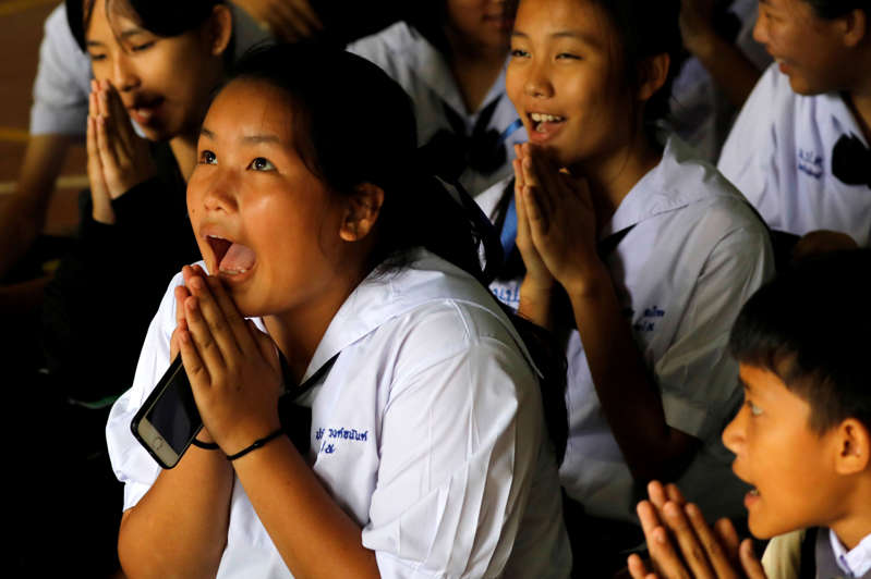 Classmates pray after their teacher announced some of the 12 schoolboys trapped inside a flooded cave have been rescued, at Mae Sai Prasitsart school, in the northern province of Chiang Rai, Thailand July 9, 2018. REUTERS/Tyrone Siu TPX IMAGES OF THE DAY