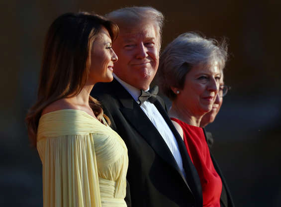 Slide 3 of 29: British Prime Minster Theresa May and her husband Philip stand together with U.S. President Donald Trump and First Lady Melania Trump at the entrance to Blenheim Palace, where they are attending a dinner with specially invited guests and business leaders, near Oxford, Britain, July 12, 2018. REUTERS/Hannah McKay