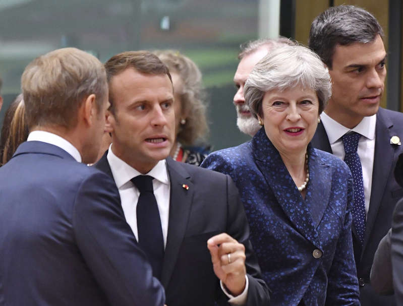 French President Emmanuel Macron, second left, speaks with European Council President Donald Tusk, left, as Spanish Prime Minister Pedro Sanchez, right, and British Prime Minister Theresa May, second right, enter the room during a round table meeting at an EU summit in Brussels, Thursday, June 28, 2018.