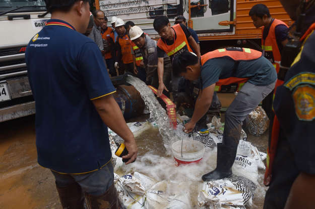 Slide 19 de 114: Thai rescue personnel drain water in the Tham Luang cave from Khun Nam Nang Non Forest Park in Chiang Rai province on June 29, 2018 during rescue operation for a missing children's football team and their coach. - Divers resumed the search for 12 boys and their football coach who have been trapped in a cave in northern Thailand for six days after the underwater rescue was halted because of rising floods. (Photo by LILLIAN SUWANRUMPHA / AFP)        (Photo credit should read LILLIAN SUWANRUMPHA/AFP/Getty Images)