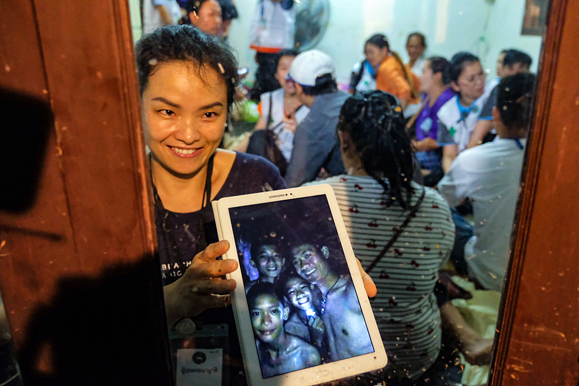 Slide 1 de 111: CHIANG RAI, THAILAND - JULY 2: Relatives of the missing boys show photos of them after the 12 boys and their soccer coach have been found alive in the cave where they've been missing for over a week after monsoon rains blocked the main entrance on July 02, 2018 in Chiang Rai, Thailand. Chiang Rai governor Narongsak Osatanakorn announced on Monday that the boys, aged 11 to 16, and their 25-year-old coach were being rescued from Tham Luang Nang Non cave after they were discovered by naval special forces and the challenge now will be to extract the party safely.