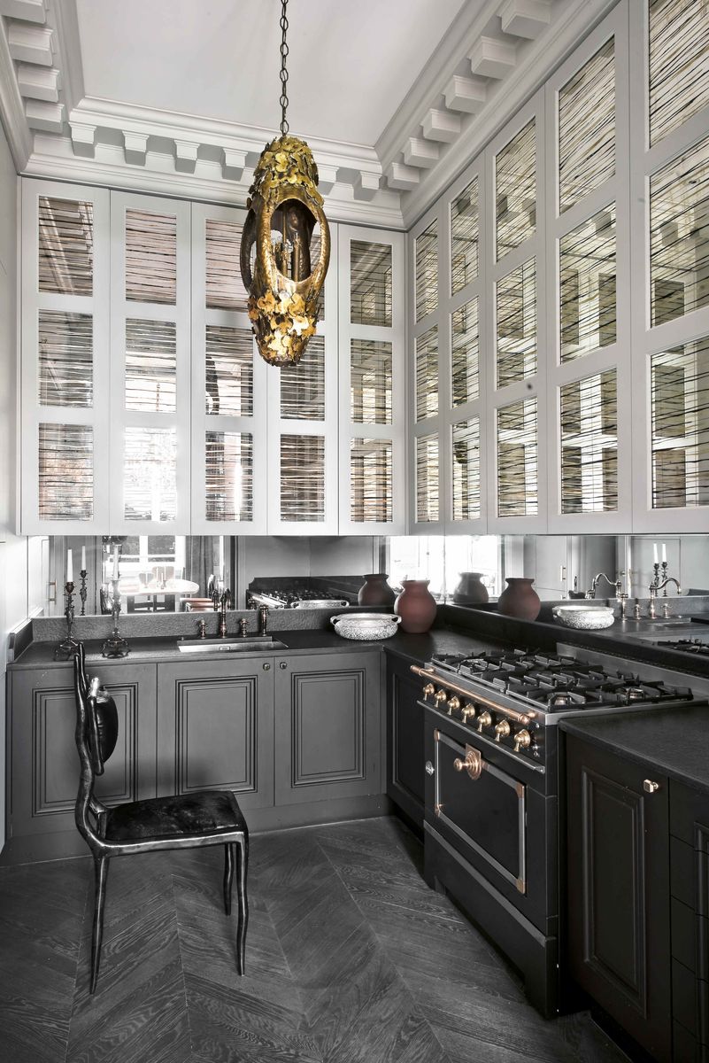 <p>Smokey tones and striking sculptural elements offer a dramatic flair to this <a href="https://www.veranda.com/home-decorators/a30145127/jean-louis-deniot-paris-flat/">quaint cook space</a> by Paris-based designer <a href="https://www.deniot.com/">Jean-Louis Deniot</a>. The upper cabinets fitted with mirrored eglomise facings "almost look like venetian blinds," notes the designer. The range is from <a href="https://www.lacornueusa.com/">La Cornue</a>. </p>