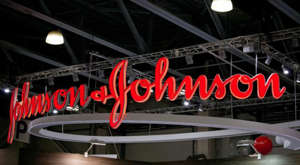a sign in front of a building: A red Johnson & Johnson (JNJ) sign hangs inside in Moscow, Russia.