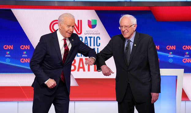 Slide 2 of 154: Democratic U.S. presidential candidates former Vice President Joe Biden and Senator Bernie Sanders do an elbow bump in place of a handshake as they greet other before the start of the 11th Democratic candidates debate of the 2020 U.S. presidential campaign, held in CNN's Washington studios without an audience because of the global coronavirus pandemic, in Washington, U.S. March 15, 2020. REUTERS/Kevin Lamarque     TPX IMAGES OF THE DAY