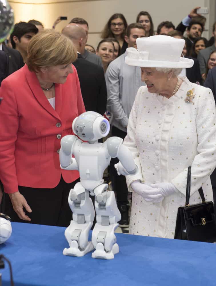 Königin Elisabeth II. und Kanzlerin Angela Merkel betrachten die Roboter an der Technischen Universität Berlin im Jahr 2015.