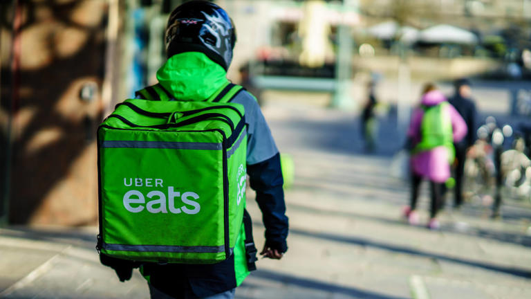 Uber eats delivery person carrying food to people who order by online app