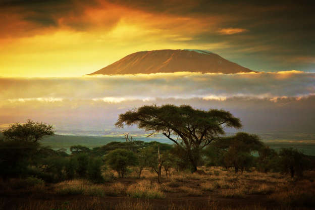 Slide 11 de 65: Mount Kilimanjaro and clouds line at sunset, view from savanna landscape in Amboseli, Kenya, Africa