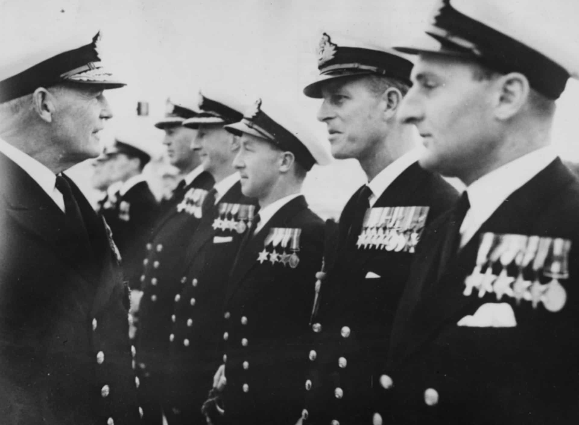 El príncipe Felipe participando en un desfile militar mientras habla con el almirante Sir John Edelsten, comandante a cargo de la flota mediterránea británica, en HMS Phoenicia (Malta), 1950.
