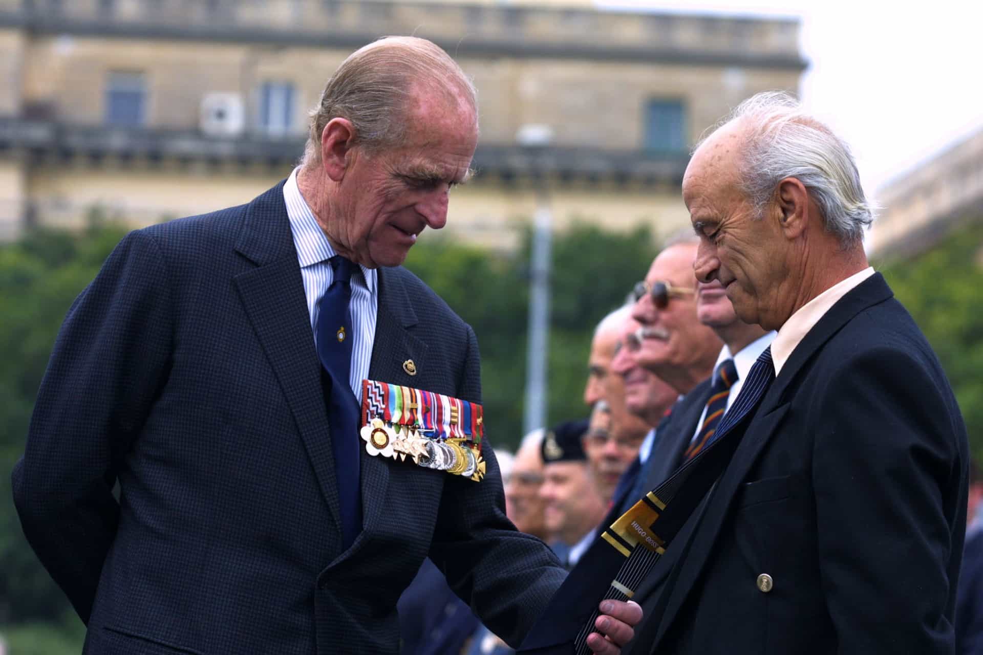 El duque de Edimburgo observando la corbata de un veterano en una ceremonia de coronación en el Cenotaph War Memorial de Malta, en Floriana, a las afueras de La Valetta (Malta).