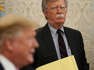 John R. Bolton wearing a suit and tie: Then National Security Adviser John Bolton listens to U.S. President Donald Trump speak during a meeting with Egyptian President Abdel-Fattah el-Sisi in the Oval Office of the White House April 9, 2019 in Washington, DC.