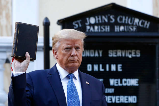 Donald Trump wearing a suit and tie: President Donald Trump holds a Bible outside St. John's Church across Lafayette Square from the White House on June 1.