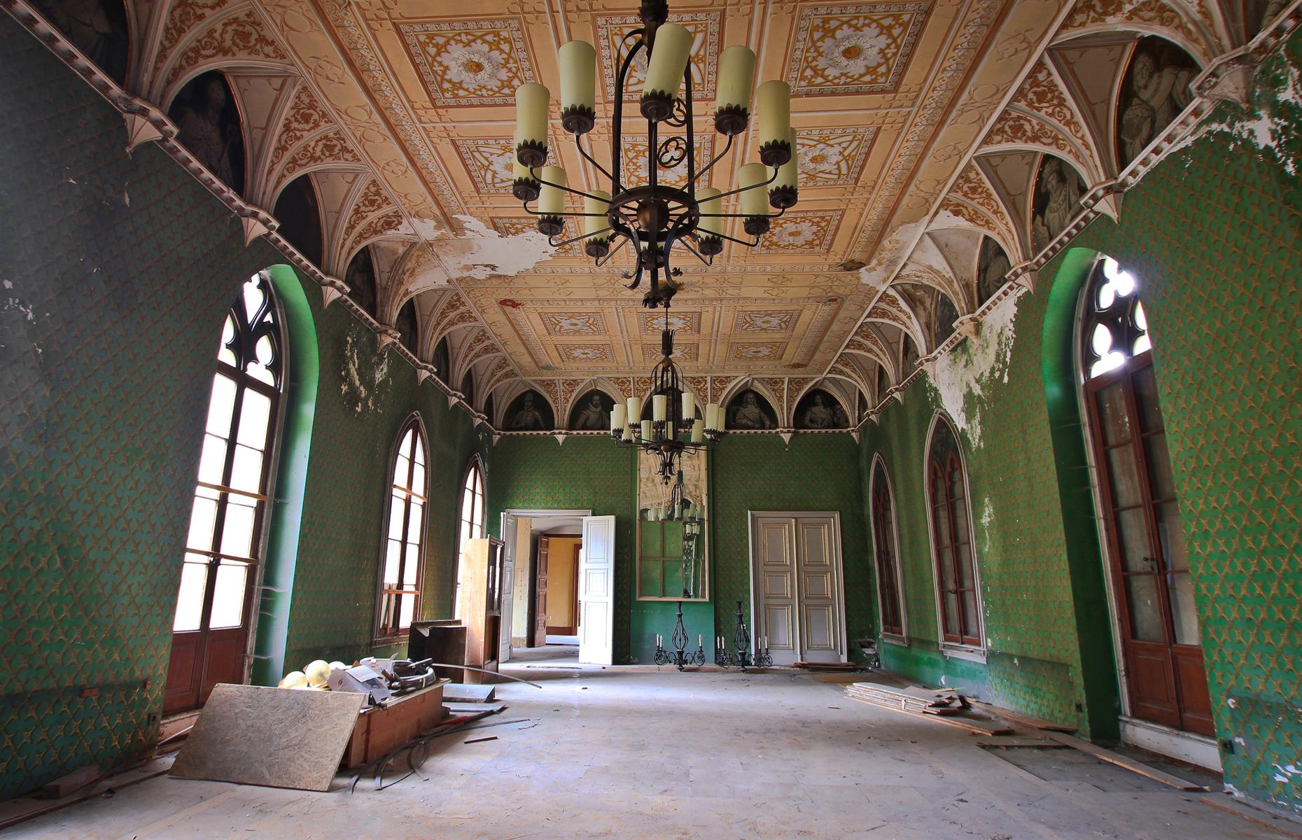 <p>In 2008 it was purchased by Russian investors but they also left the castle to rot even further over the years and eventually the state was forced to take action to save Reinhardsbrunn. This room would once have been a place of high society but with peeling wallpaper and debris littered over the floor, it's no longer in its prime, though the decorative carvings are still breathtaking.</p>