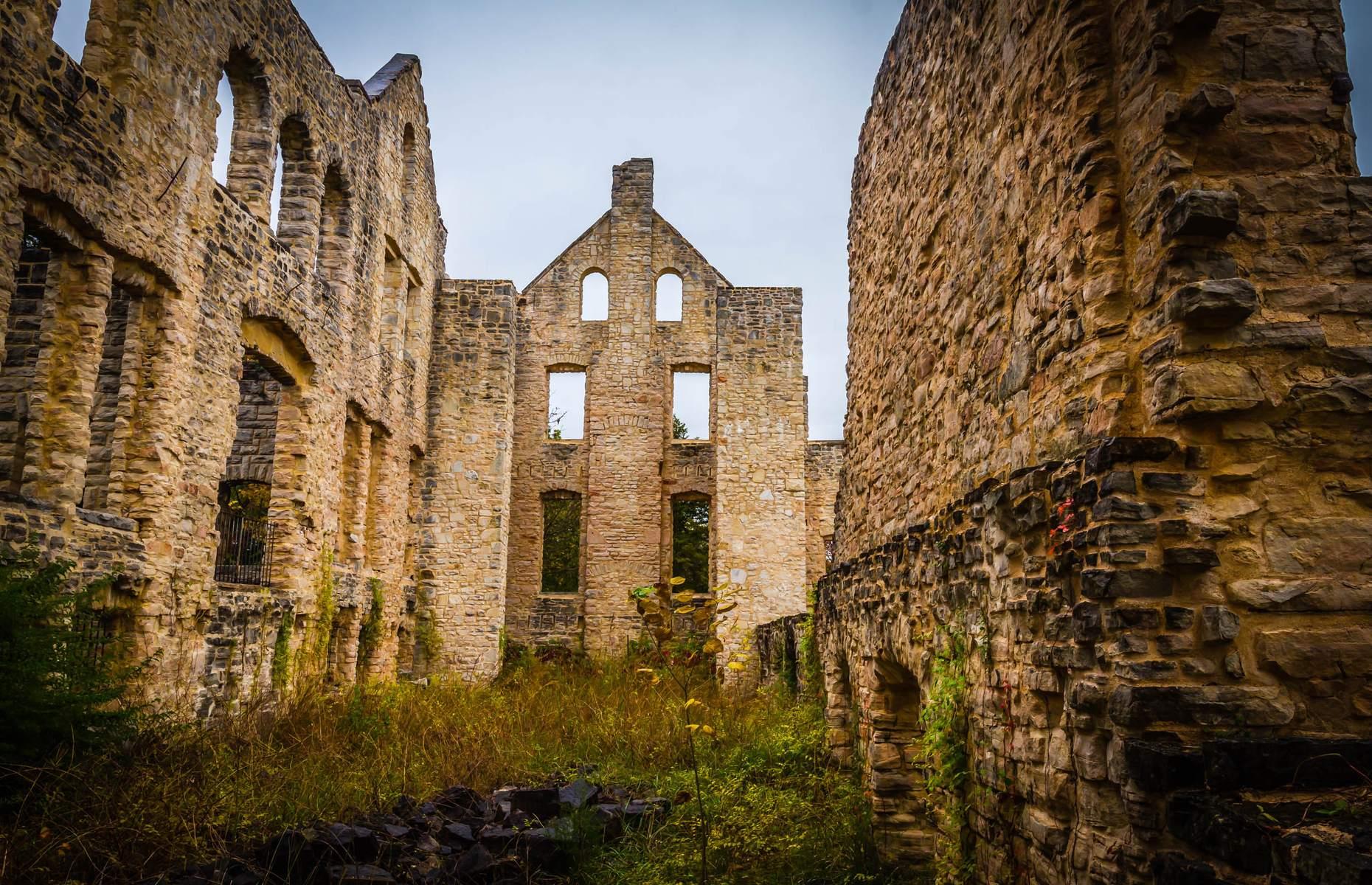 Slide 8 of 29: After his death, Snyder’s sons continued construction and by the early 1920s, the castle was complete. However, during the Depression in the 1930s, the family business went into decline and in 1942 the castle was gutted by a fire. It was never rebuilt and lay empty and abandoned.