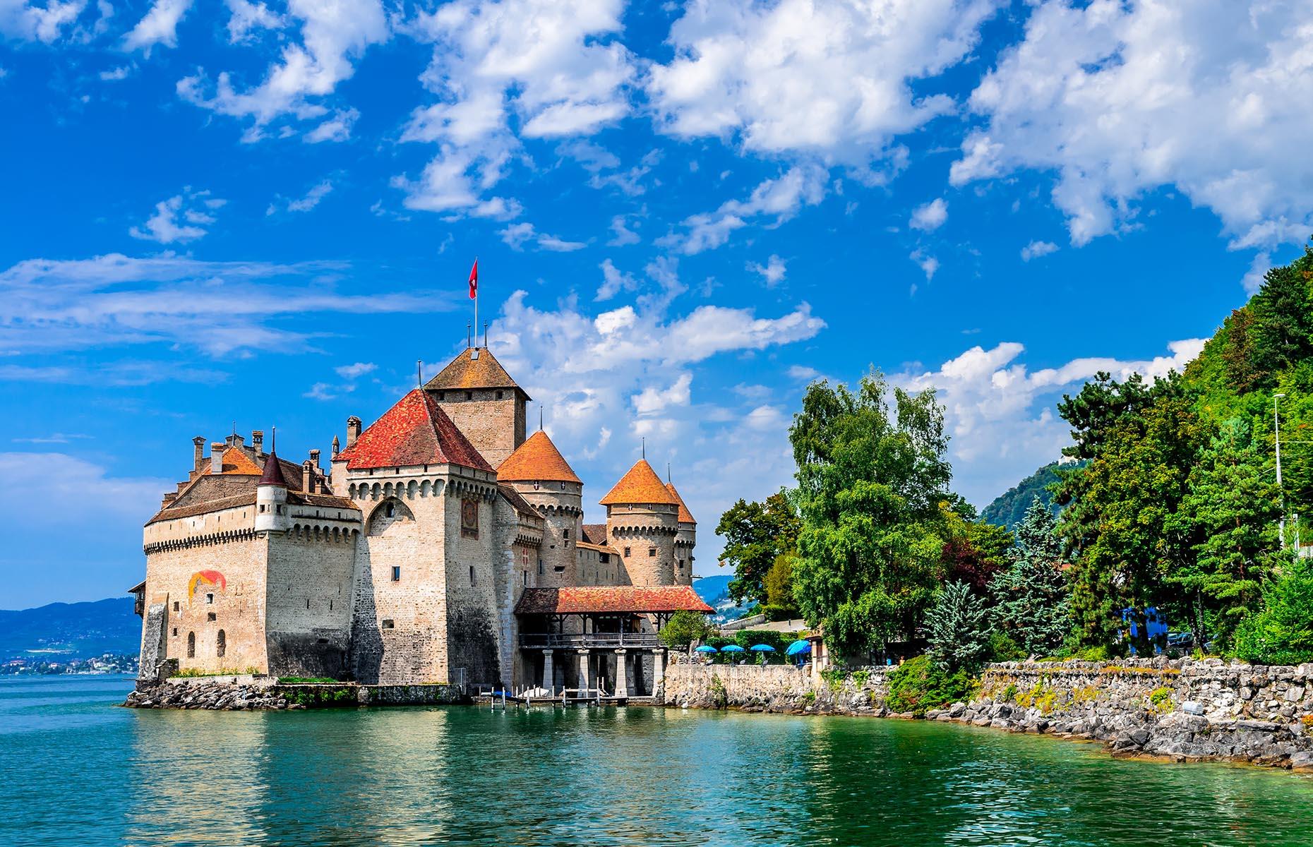Slide 10 of 61: One of Switzerland's most popular historic sites, the picture-perfect Chillon Castle nestles on an island on the edge of Lake Geneva. The castle dates back to the 11th century and it served as the summer residence for the Counts of Savoy from the 1200s until the 16th century, when it was converted into a prison, though a jail existed in the castle from the 13th century onwards.