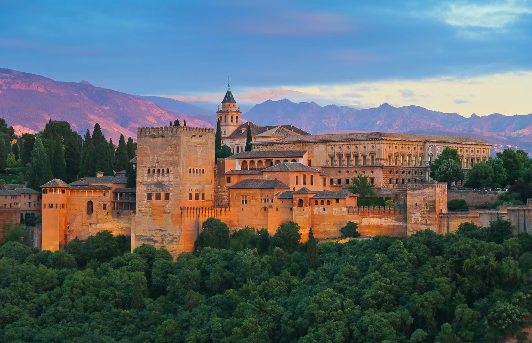Slide 24 of 61: Built between 1238 and 1358, Granada's sprawling Alhambra is an impressive Moorish masterpiece. The name Alhambra comes from an Arabic phrase meaning red castle and was given due to the reddish hue of its towers and walls. It was described as "a pearl set in emeralds" by Moorish poets, referring to its location within the woods.