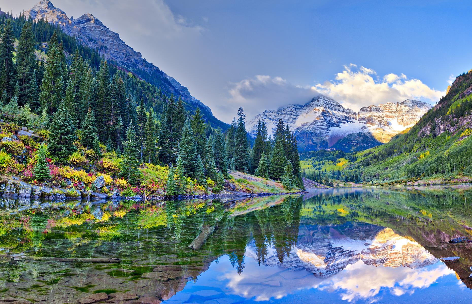 Slide 54 of 59: The Elk Mountains in Colorado are crammed full with inspiring viewpoints and enchanting landscapes. Yet of all of them, nowhere is quite like the Maroon Bells. As two of the highest peaks in the region, these soaring mountains reflect in Crater Lake during sunny days, creating a natural mirror that captures the pure simplicity of this untouched landscape.