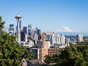 A classic view of Seattle downtown district with the famous Space Needle tower and the Mount Rainier snow covered mountain in the background in Washington state, USA