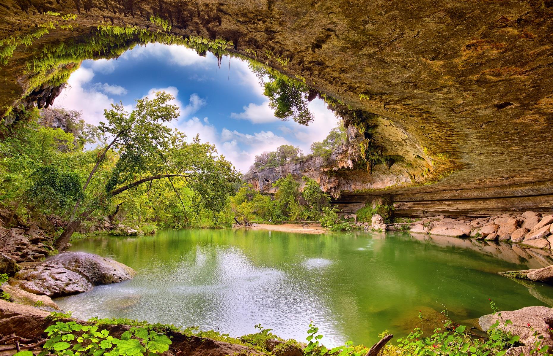 Slide 45 of 59: It's hard to resist jumping in this natural swimming hole, around 20 miles (32km) west of Austin. Entirely inviting, the shimmering emerald pool was once hidden underground until its limestone roof collapsed, revealing this oasis. Now a popular swimming spot for locals and visitors alike, the pool is fed by a 50-foot (15m) waterfall and is only accessible to those with a reservation.