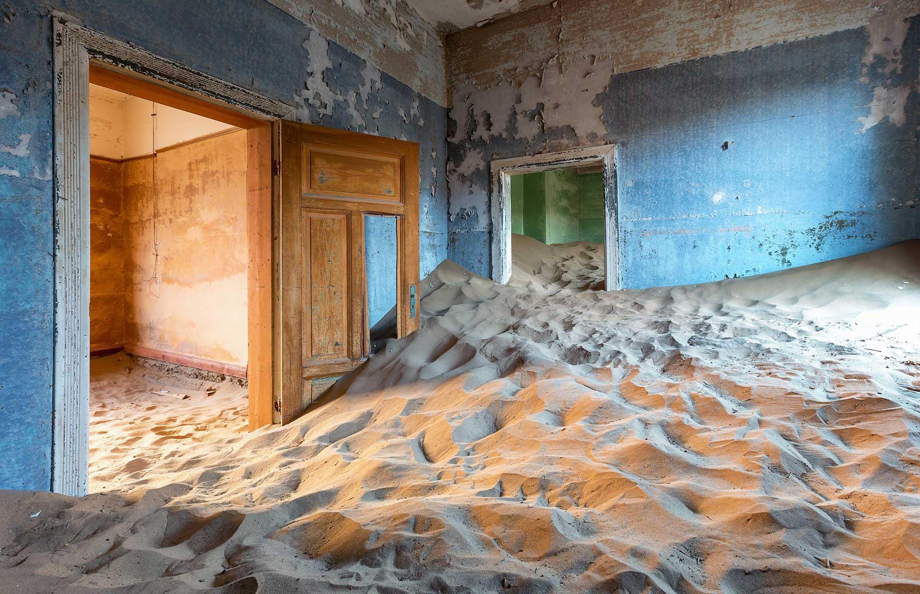 Slide 53 of 64: Desert sand seeps into every crevice of Kolmanskop, a ghost town in the Namib. It covers the floors of now derelict houses, forcing doors off their hinges as it reclaims the space. A mere century ago, Kolmanskop was a thriving miners’ town. In 1908, a local railway worker stumbled across what he thought was a diamond in the area. Once his find was verified, predominantly German miners rushed here in the hope of making their fortune.